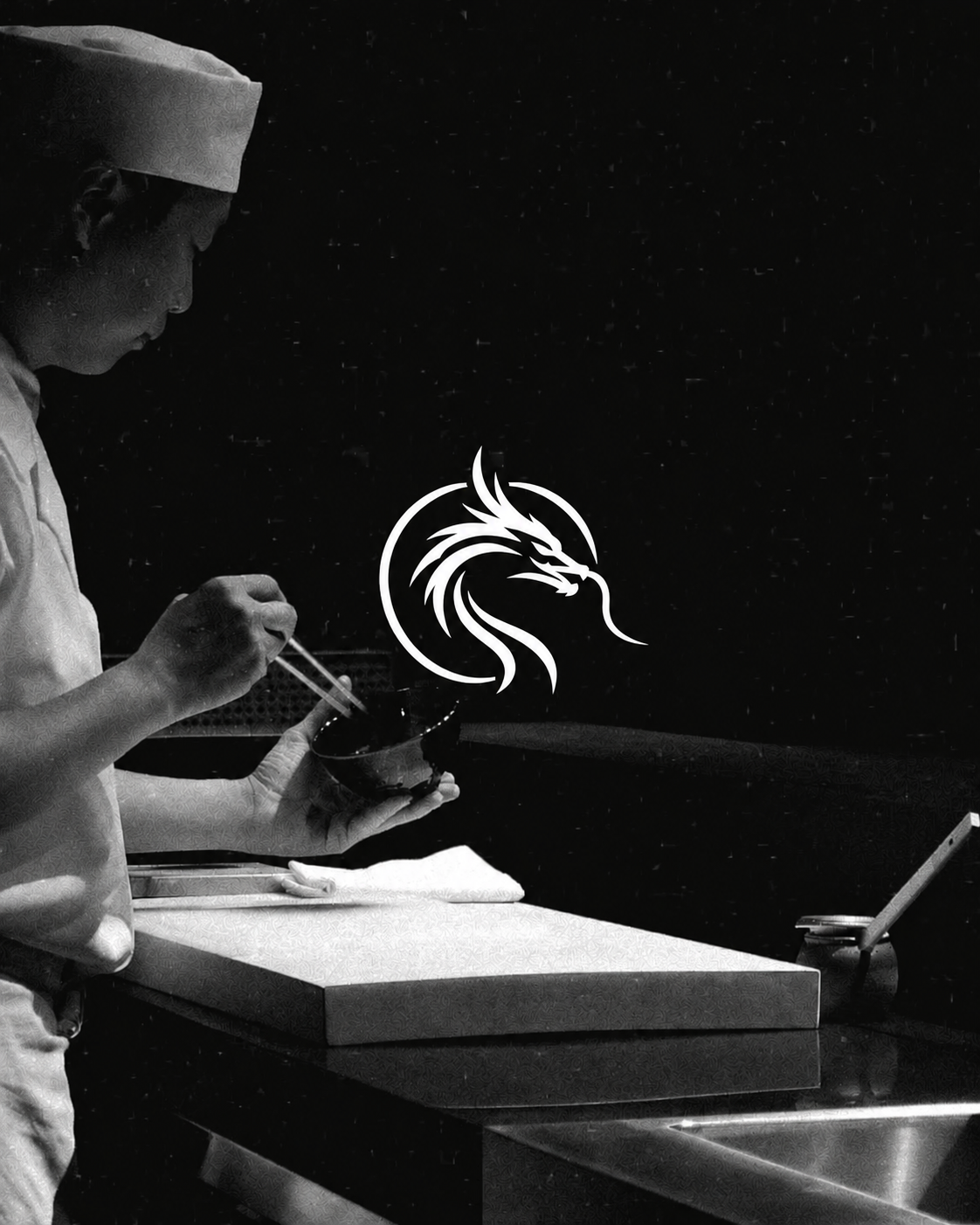 Black-and-white photograph of a chef at work with the RED RYUU dragon emblem visible in the scene